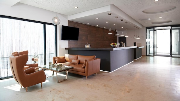 Een moderne woonkamer met een bank, salontafel en een keukenhoek met een bar.