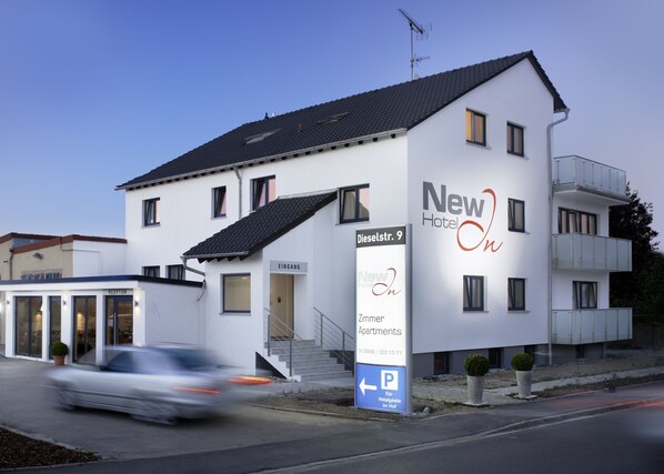 A modern hotel named "New Hotel In" with a sign indicating "Eingang" (Entrance) and "Zimmer Apartments" (Apartments). - HOTEL NEW IN - Ingolstadt - Gaimersheim (Gaimersheim)