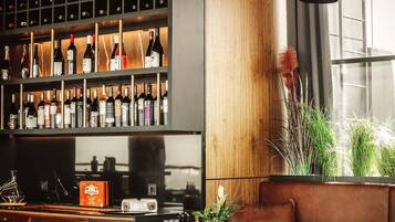 Un'area bar moderna con un portavino, sedute in pelle e un'ampia finestra.