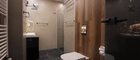 Un baño moderno con ducha, inodoro y lavamanos.