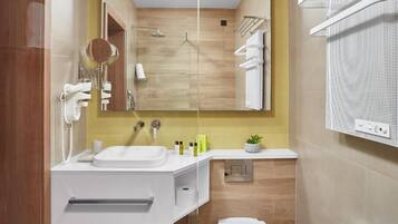 Een moderne badkamer met een wit aanrichtmeubel, een spiegel, een douche en een handdoekhouder.