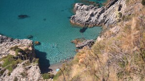 A coastal landscape with clear turquoise waters, rocky cliffs, and sparse vegetation. - Agriturismo La Petrosa (Ceraso)