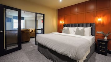 Ein Hotelzimmer mit Bett, Nachttisch, Spiegel und einer Sitzecke mit Sofa.