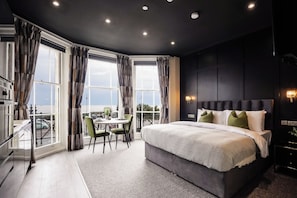 Un dormitorio moderno con una cama grande, una mesa de comedor y vistas a la ciudad.