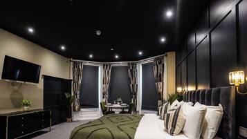 Ein modernes Schlafzimmer mit Bett, Fernseher, Schreibtisch und Stuhl.