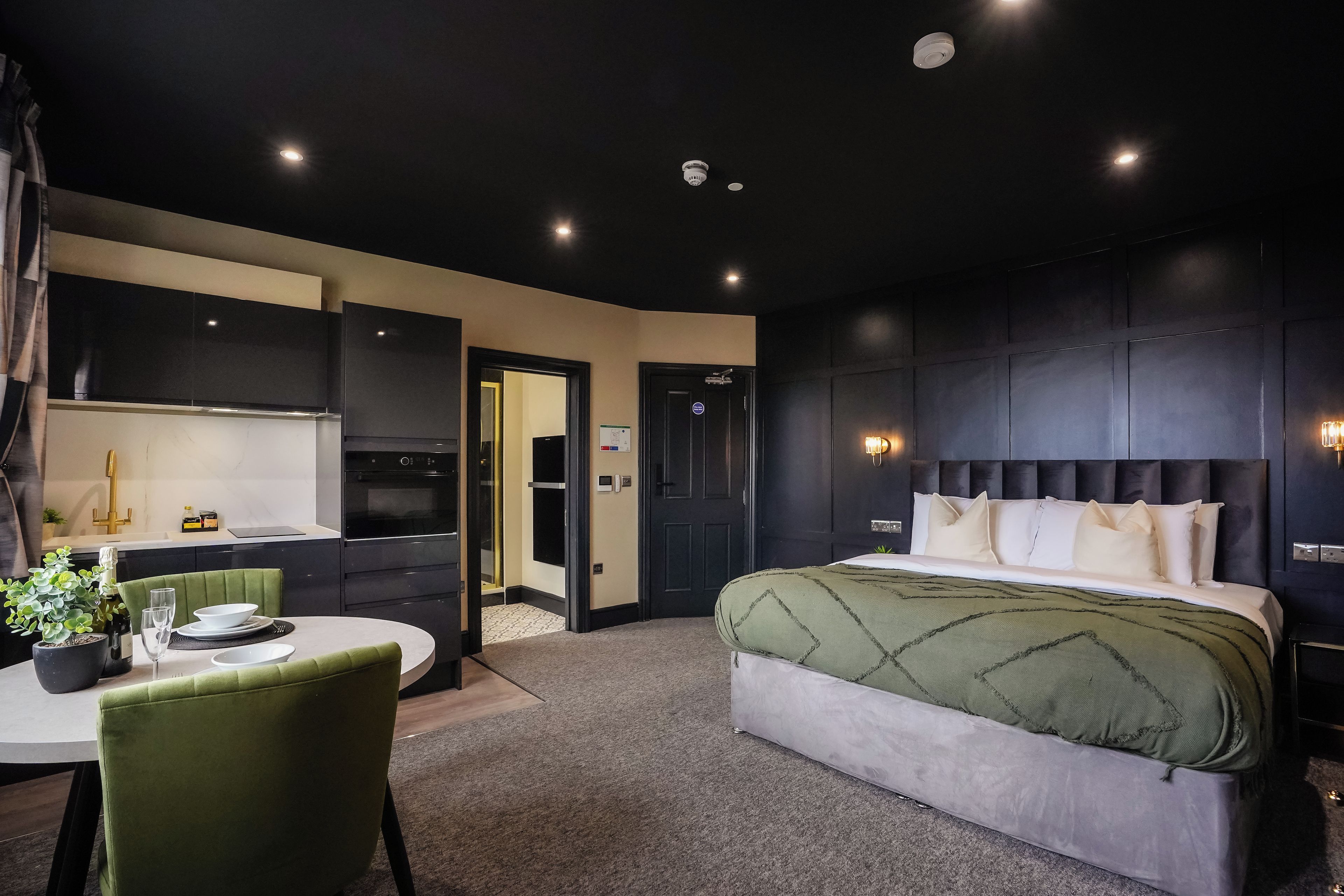 Une chambre d’hôtel moderne dotée d’un grand lit, d’un coin repas et d’une kitchenette.