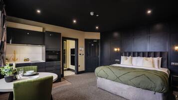 Une chambre d’hôtel moderne dotée d’un grand lit, d’un coin repas et d’une kitchenette.