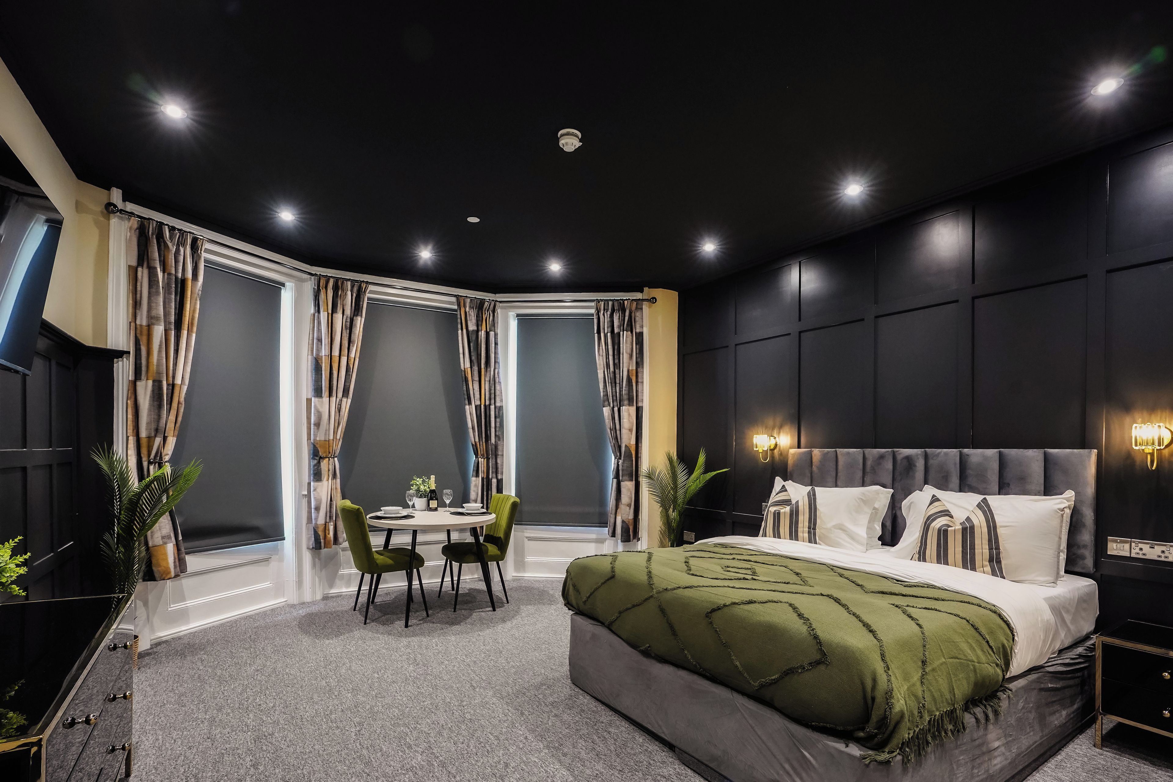 Une chambre moderne avec un grand lit, une table à manger et deux chaises.