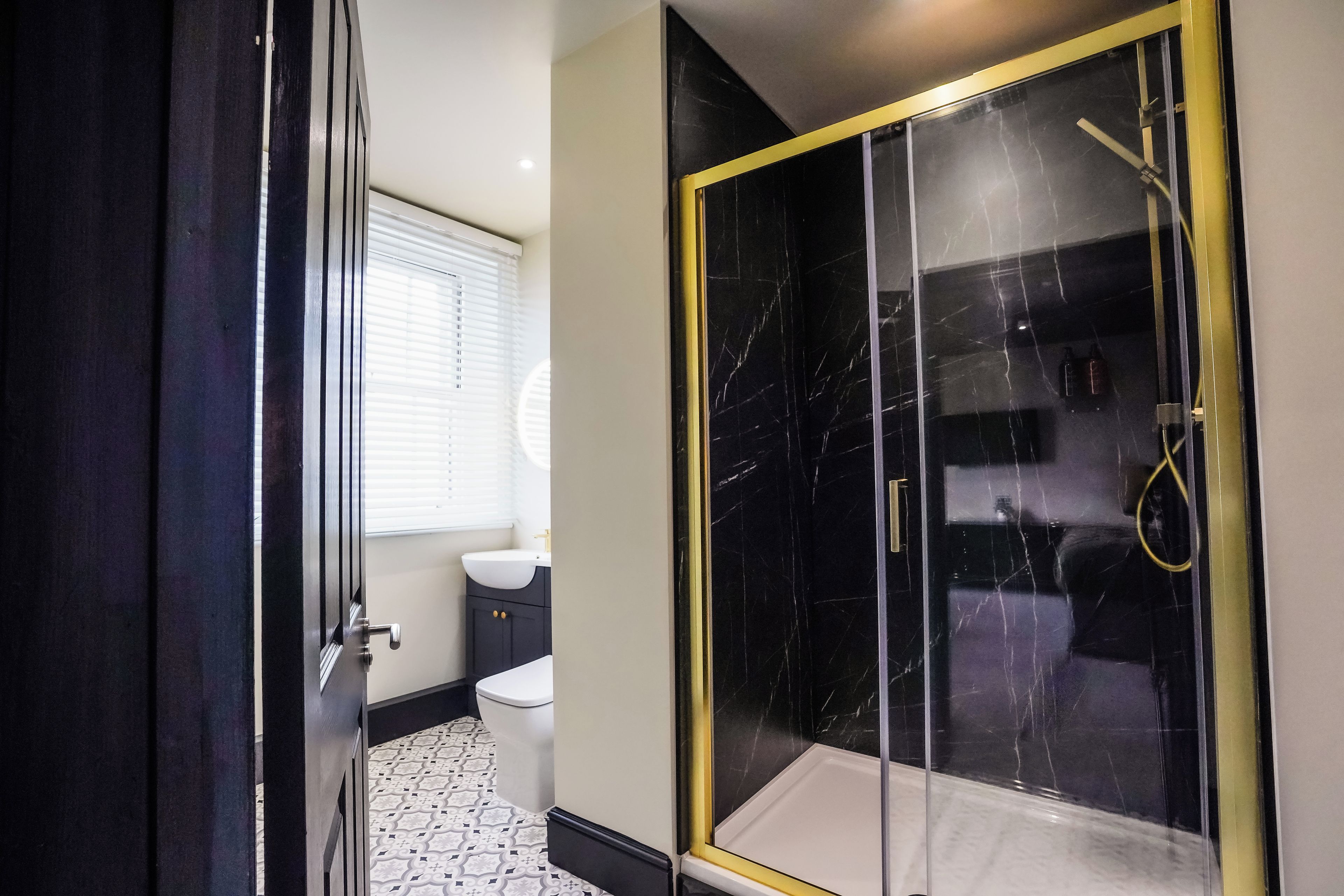 A bathroom with a toilet, sink, and a glass-enclosed shower area.