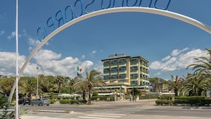 A hotel entrance with a curved sign reading "HOTEL SIESTA". - Hotel Siesta (Camaiore)