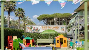 A children's play area with a ping pong table, play structures, and a banner reading "SIESTA LAND". - Hotel Siesta (Camaiore)
