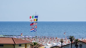 A beach with multiple flags, including the EU flag, and a clear view of the sea. - Hotel Siesta (Camaiore)