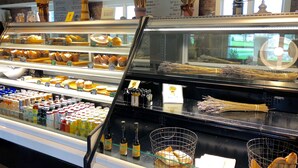 Une vitrine de boulangerie présentant diverses pâtisseries et un menu de boissons au café.