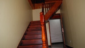 Una escalera de madera con barandilla que lleva a una plataforma.