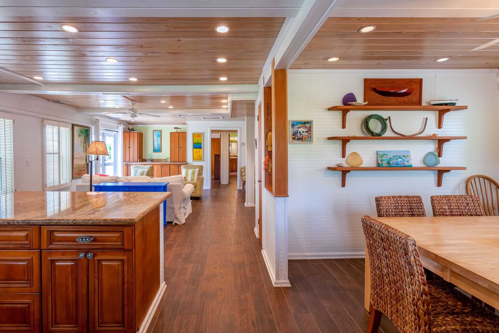A spacious kitchen with wooden cabinets and a dining area with wicker chairs.