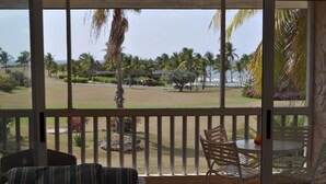 A room with a view of a landscaped area featuring palm trees, a pool, and a beach. - Gentle Winds, St. Croix, U.S.V.I. - come unwind! (St. Croix)