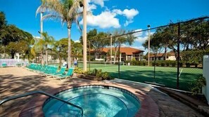 A pool area with lounge chairs and a tennis court. - Shorewalk 205 - Bradenton-  The Palms condo 2 Bedroom / 2 Bath,  5 miles from  Anna Maria Island and near Img, maximum occupancy of 4 people. (Bradenton)