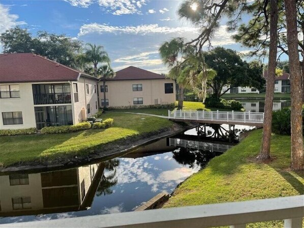Una zona residencial con dos casas, un pequeño puente y un estanque.