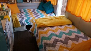 Cozy retreat with two beds, a bedside table, and a window.