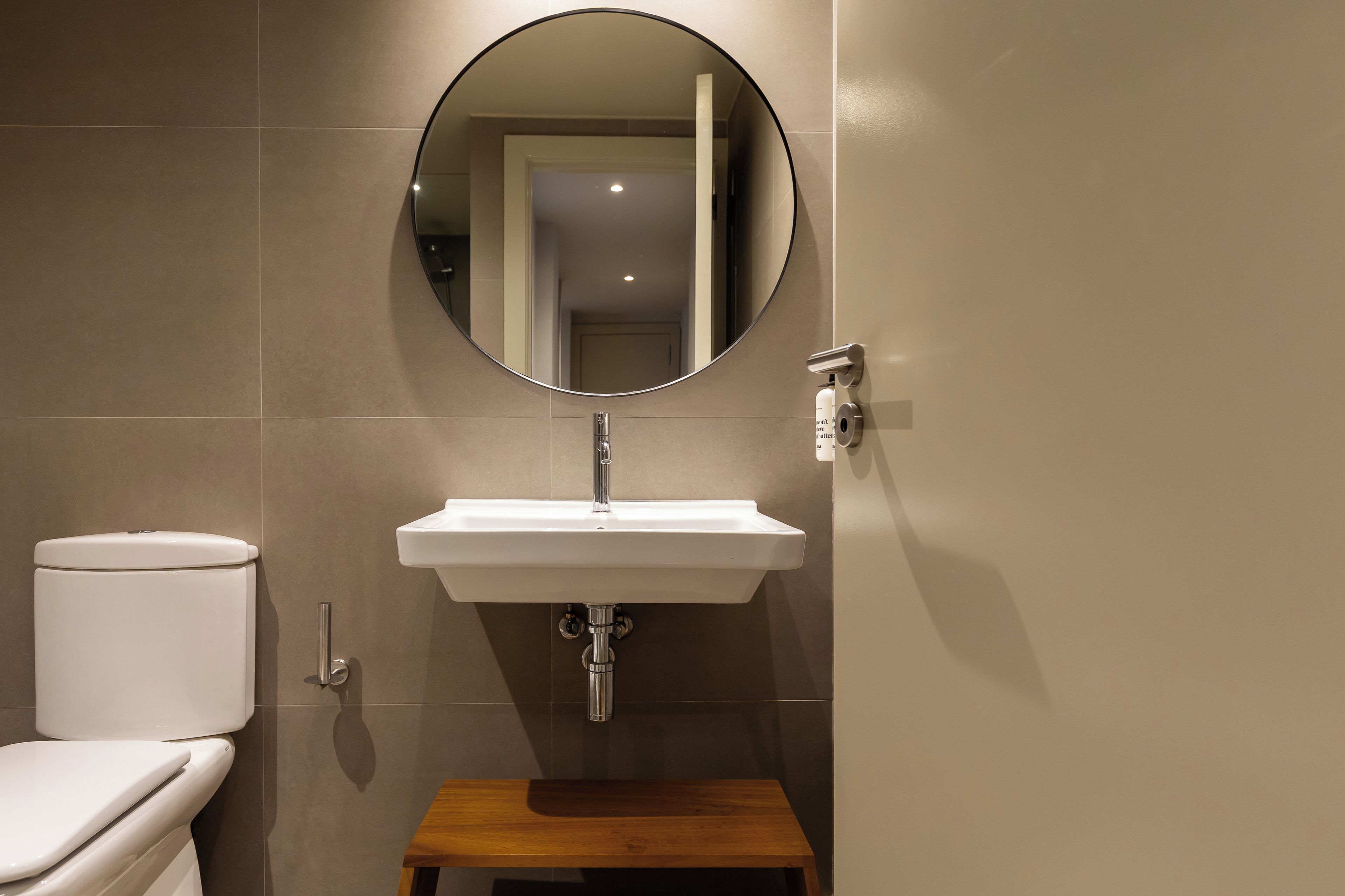 A bathroom with a white toilet, a white sink, and a mirror.