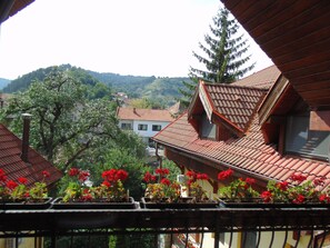 Una zona residencial con casas de techo rojo y un árbol de hoja perenne destacado.