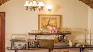 Una barra de desayuno con cafetera, tostadora y diversos recipientes de comida.