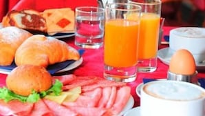 A breakfast table with croissants, ham, cheese, and juice glasses. - Hotel Friuli (Lignano Sabbiadoro)
