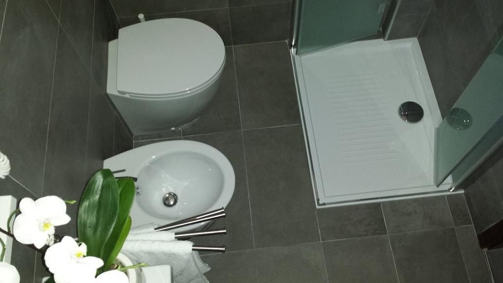 A bathroom with a toilet, sink, and glass shower enclosure.