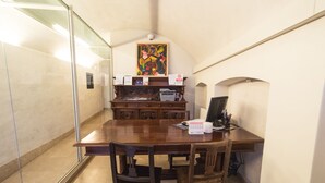 A conference room with a wooden table, chairs, a printer, and a framed artwork on the wall. - Academia Resort (Bergamo)