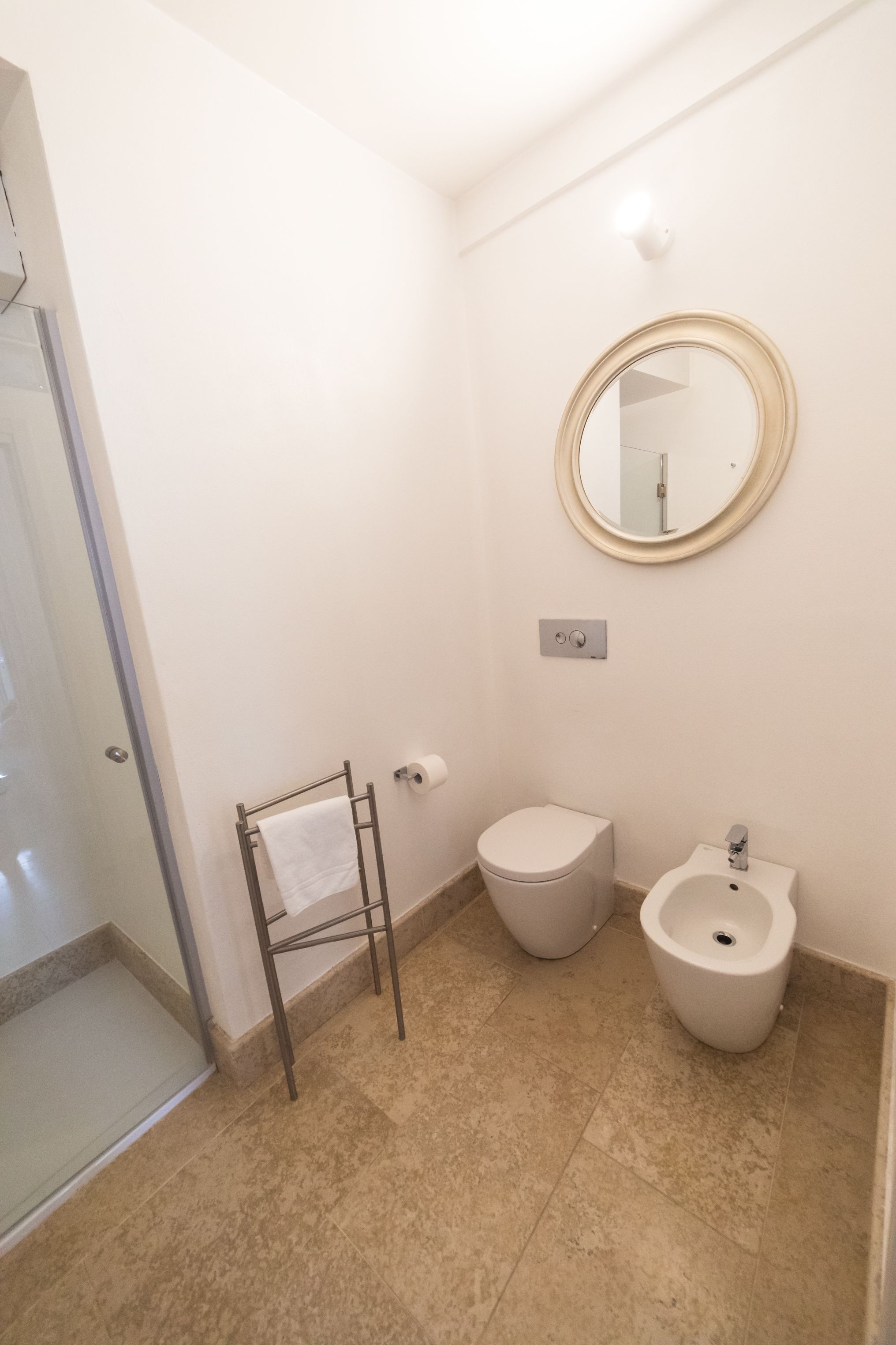 Ein Badezimmer mit Toilette, Bidet und Handtuchhalter.