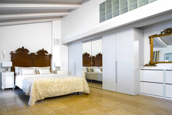 A bedroom with a large bed, a wardrobe, and a mirror. - Academia Resort (Bergamo)