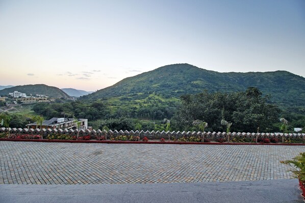 A paved area with a view of a mountain and buildings in the background. - Kumbhalgarh Fort Resort (Kumbhalgarh)