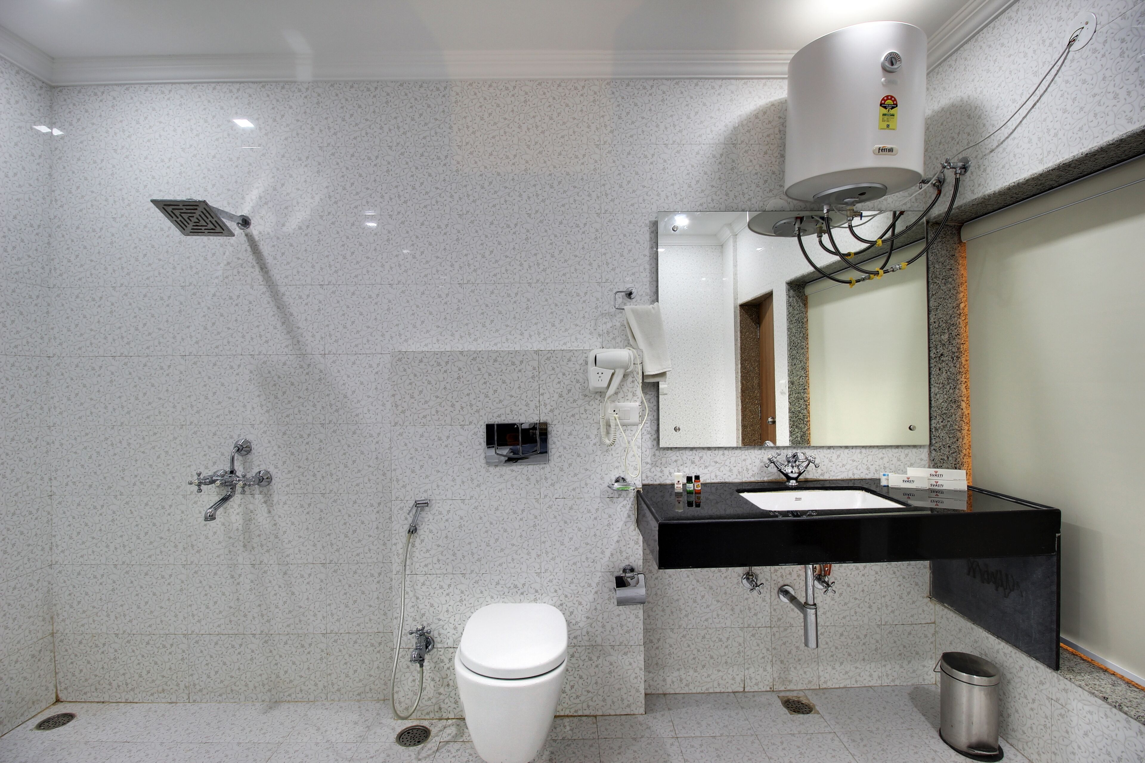 A modern bathroom with a toilet, sink, mirror, and shower.