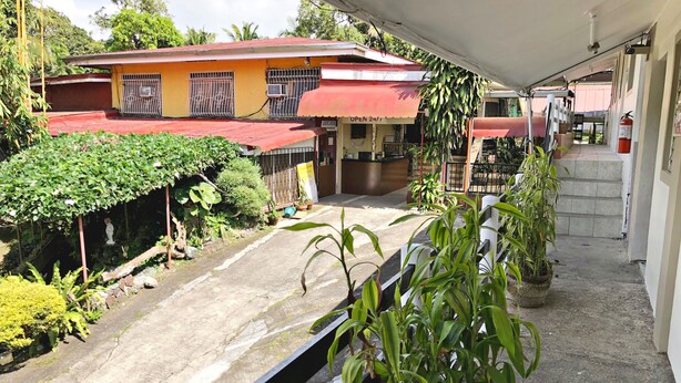 A building with a red awning and a sign indicating 'OPEN 24H'. - Famous Inn (Tagaytay)