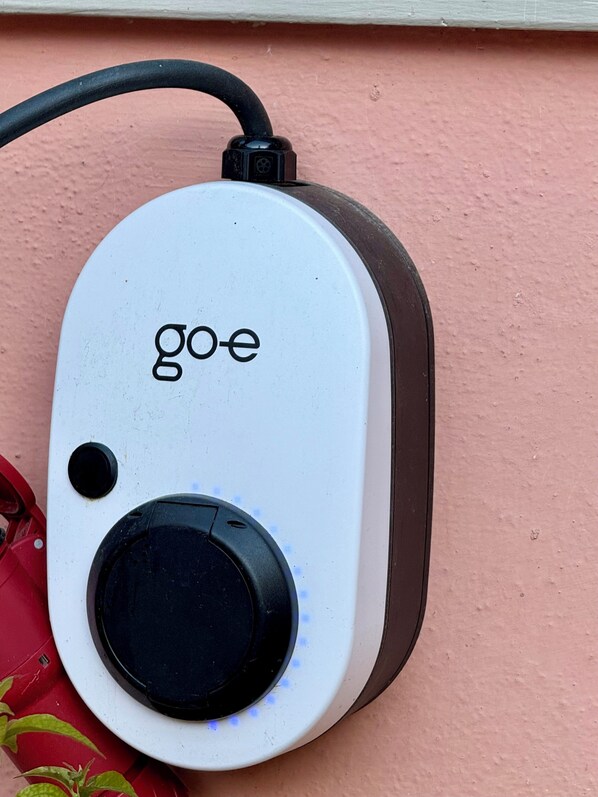 Un dispositivo con una perilla circular y la palabra 'goe' sobre un fondo blanco.
