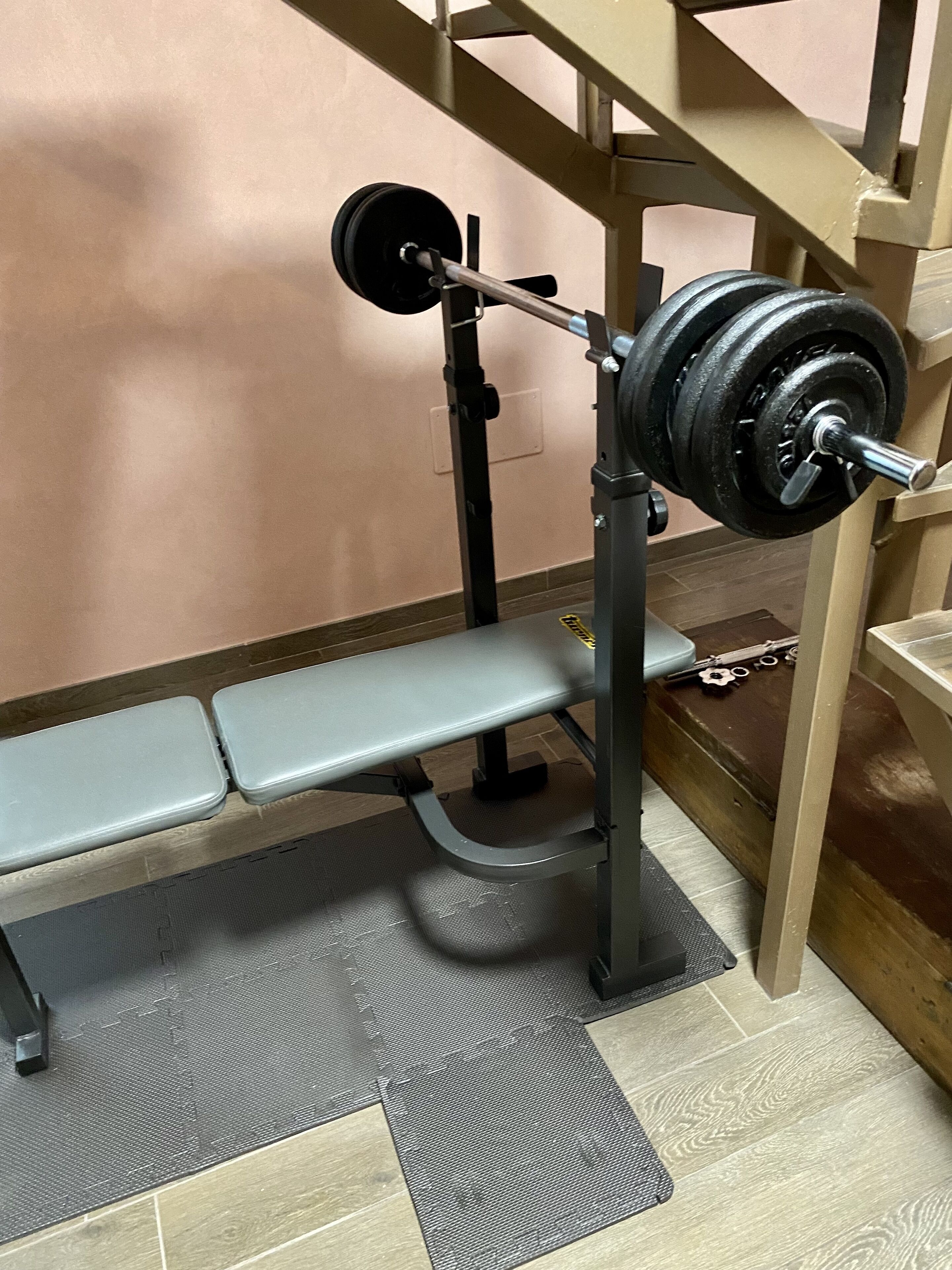Panca da pesi con bilanciere e pesi in una palestra.