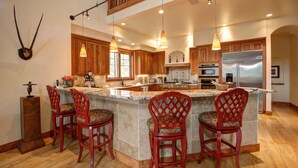 Una cocina amplia con una isla grande, armarios de madera y electrodomésticos modernos.