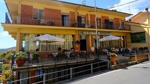 A yellow building with a balcony, outdoor seating, and a sign that reads "AMELIA DREAM VIEW HOTEL RESTORANTE." - Amelia Dream View (Marliana)