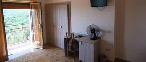 Una habitación con escritorio, silla y televisor montado en la pared.