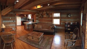 A log cabin interior with a kitchen, dining area, and living room. - Rustic Log Cabin next to the Hoosier National Forest in the Ohio River Valley (Derby)