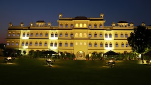 Un hotel grande e iluminado con varios pisos y una entrada central.