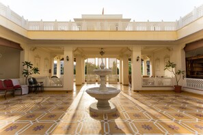 A courtyard with a central fountain, ornate columns, and patterned flooring. - Grand Uniara (Jaipur)