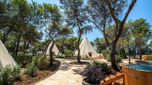A campsite with tents, a hot tub, and a stone pathway. - Arena One 99 Glamping (Medulin)