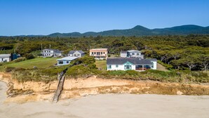 A coastal residential area with houses on a cliff overlooking the beach. - Ocean Front Home With Hot Tub On Miles Of Sandy Beach! (Yachats)