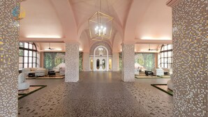 Eine geräumige Lobby mit hoher Decke, einem zentralen Kronleuchter und Sitzbereichen auf beiden Seiten.