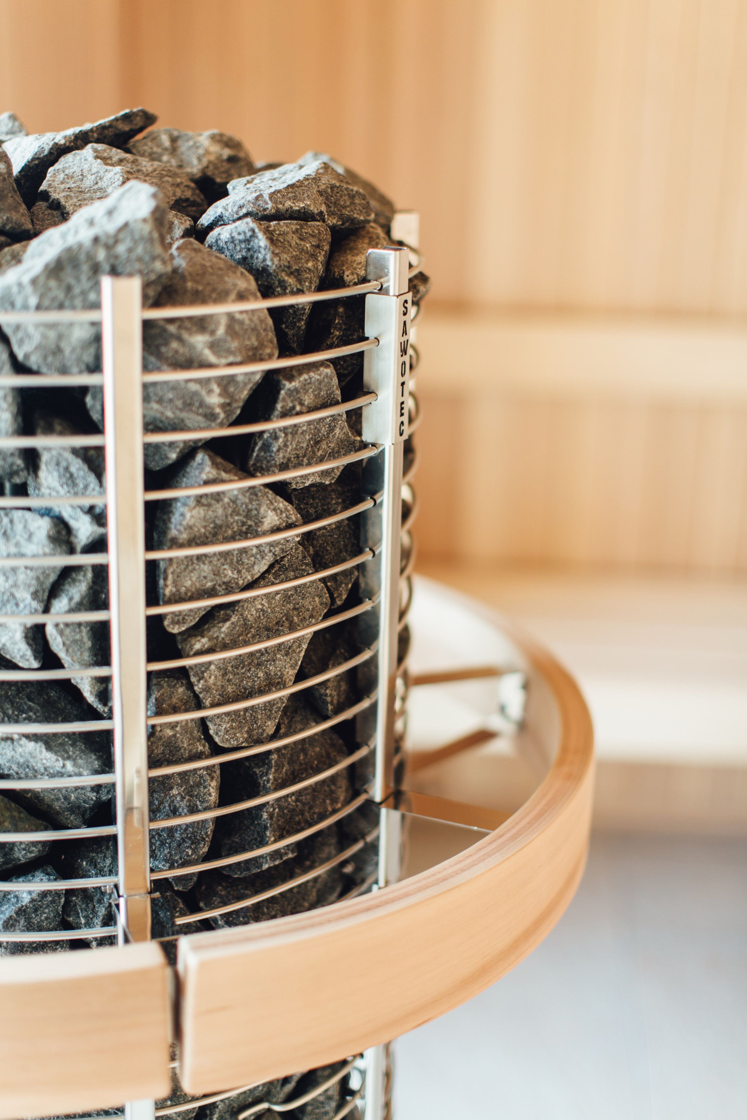 A metal rack holding rocks, likely for a sauna or hot tub.