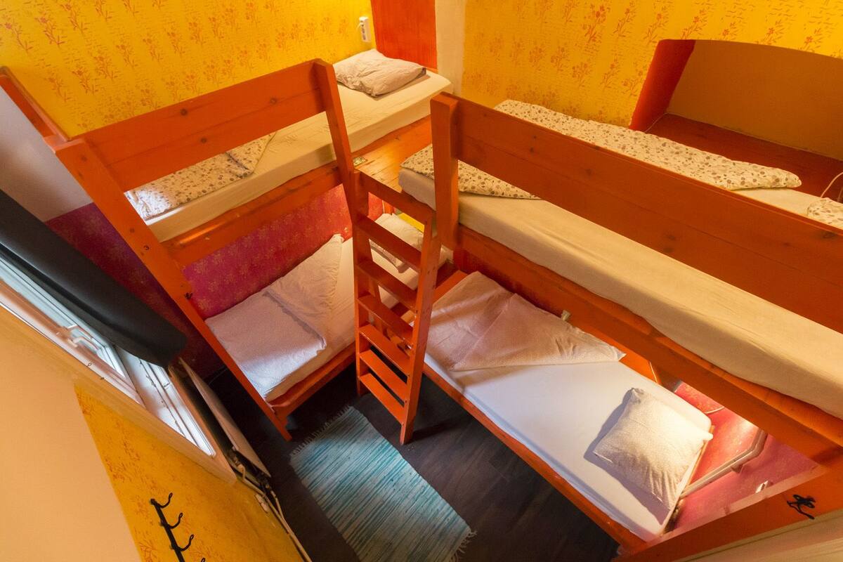 A bunk bed room with wooden frames and a ladder.
