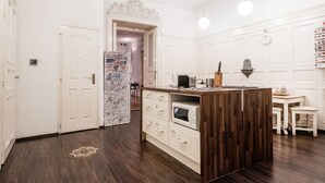 Een moderne keuken met een houten eiland, witte kasten en een inbouwmagnetron.