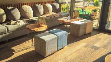 A modern interior with a sofa, ottomans, and round tables.