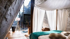 A bedroom with a large bed, white curtains, and a view of trees through a window. - Pino Nature Hotel, BW Premier Collection (Sarajevo)